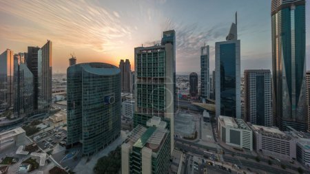 Téléchargez les photos : Dubai international financial center skyscrapers panorama with cloudy blue sky aerial during all day until sunset. Shadows moving fast and sun reflected from glass surface - en image libre de droit
