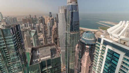 Photo for Panorama showing Dubai Marina and JLT with JBR district at morning. Traffic on highway between skyscrapers aerial. Modern towers and construction site. Yachts floating in harbor - Royalty Free Image