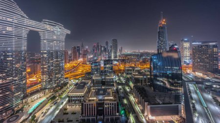 Foto de Futurista Dubai Downtown y el horizonte del distrito financiero durante toda la noche. Muchas torres iluminadas y rascacielos con tráfico en las calles con luces apagadas - Imagen libre de derechos