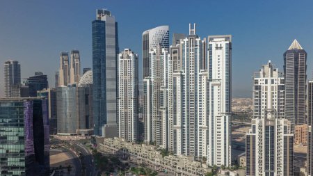 Foto de Bay Avenue durante el amanecer con torres modernas desarrollo residencial en Business Bay aérea, Dubai, Emiratos Árabes Unidos. Rascacielos con reflejos solares de superficie de vidrio - Imagen libre de derechos