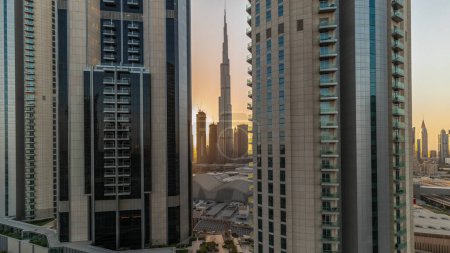 Photo for Tallest skyscrapers in downtown dubai located on bouleward street near shopping mall aerial during all day with shadows moving fast. Walking area with rooftop gardens - Royalty Free Image