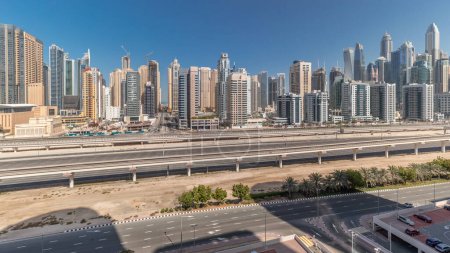 Foto de Panorama que muestra los rascacielos de Dubai Marina y la carretera Sheikh Zayed con antena de metro. Tráfico en una autopista cerca de torres modernas, Emiratos Árabes Unidos - Imagen libre de derechos