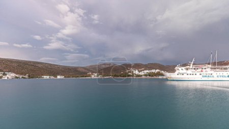 Foto de Panorama showing Amorgos island timelapse at evening during sunset. Traditional Greece - white houses on hills and ship in sea port in harbor, Cyclades - Imagen libre de derechos