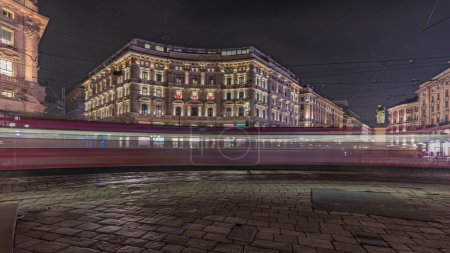 Foto de Panorama showing the Cordusio Square night timelapse. Illuminated historic buildings, monument and tram traffic. One of squares in the center of the city at the crossroads of six old streets. - Imagen libre de derechos