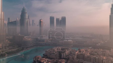 Photo for Aerial view morning fog covered Dubai International Financial Centre district. Office towers and hotels with modern skyscrapers and mall during sunrise - Royalty Free Image