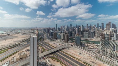 Téléchargez les photos : Panorama montrant l'horizon du centre-ville de Dubaï avec baie d'affaires. Vue aérienne de nombreux gratte-ciel modernes avec ciel bleu nuageux. Émirats arabes unis. - en image libre de droit