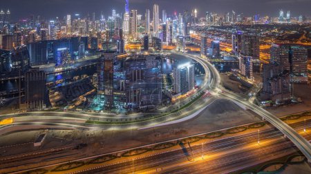 Foto de Panorama que muestra el horizonte de Dubai con la bahía de negocios y la noche del centro de distrito. Vista aérea de muchos rascacielos modernos y tráfico ocupado en la carretera al khail. Emiratos Árabes Unidos. - Imagen libre de derechos