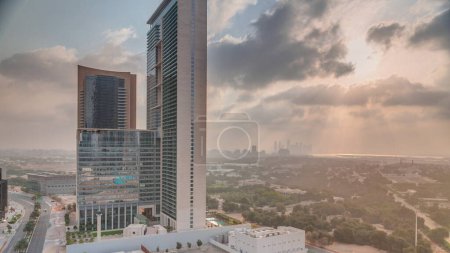 Photo for Sunrise in Dubai International Financial district transition. Aerial view of business office towers at morning. Skyscrapers with hotels near downtown - Royalty Free Image