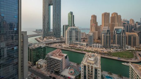 Foto de Panorama mostrando Dubai Marina con varios barcos y yates estacionados en el puerto y rascacielos alrededor de la antena del canal. Torres del distrito JBR en segundo plano - Imagen libre de derechos