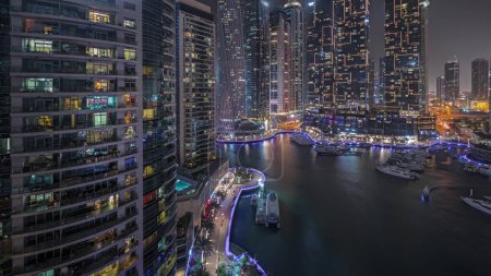 Foto de Panorama showing luxury yacht bay in the city aerial night in Dubai marina. Modern skyscrapers along waterfront promenade and boats floating in harbor - Imagen libre de derechos