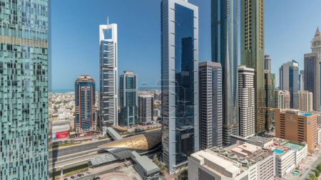 Foto de Panorama que muestra una vista aérea del Distrito Financiero Internacional de Dubai con muchos rascacielos. Tráfico en la carretera Sheikh Zayed cerca de torres de varios pisos. Dubai, Emiratos Árabes Unidos. - Imagen libre de derechos