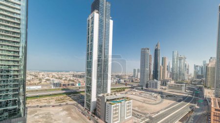 Foto de Panorama que muestra la vista aérea del centro de Dubái y el horizonte de la bahía de negocios con muchas torres timelapse. Área de negocios en la ciudad urbana inteligente. Rascacielos y edificios de gran altura desde arriba, Emiratos Árabes Unidos. - Imagen libre de derechos