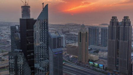 Photo for High-rise buildings on Sheikh Zayed Road in Dubai aerial timelapse, UAE. Skyscrapers in international financial district from above during sunset. City walk houses and villas on a background - Royalty Free Image