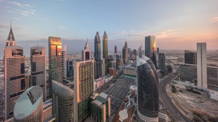 Foto de Vista panorámica del horizonte de los edificios de gran altura en Sheikh Zayed Road en Dubai timelapse aéreo durante todo el día desde el amanecer hasta el atardecer, Emiratos Árabes Unidos. Rascacielos en el Centro Financiero Internacional desde arriba - Imagen libre de derechos