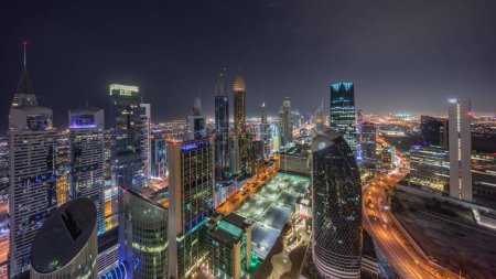 Téléchargez les photos : Vue panoramique Skyline des immeubles de grande hauteur sur Sheikh Zayed Road à Dubaï pendant toute la nuit timelapse, EAU. Des gratte-ciel éclairés de la place financière internationale d'en haut - en image libre de droit