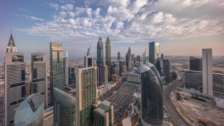 Téléchargez les photos : Skyline vue panoramique sur les immeubles de grande hauteur sur Sheikh Zayed Road à Dubaï timelapse aérien pendant toute la journée du lever au coucher du soleil, Émirats arabes unis. gratte-ciel dans la place financière internationale d'en haut - en image libre de droit