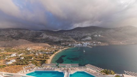 Foto de Panorama que muestra el timelapse aéreo de la isla de Amorgos desde arriba con nubes antes del atardecer. Grecia tradicional - casas blancas en colinas y mar turquesa, Cícladas - Imagen libre de derechos