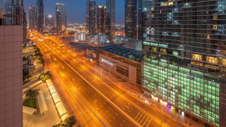 Téléchargez les photos : Business bay district skyline architecture moderne nuit au jour passage timelapse d'en haut. Panorama aérien des gratte-ciel et des tours de Dubaï près de l'autoroute principale avant le lever du soleil. Trafic au carrefour - en image libre de droit