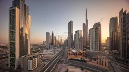 Foto de Vista aérea del horizonte del centro de Dubái durante el amanecer con largas sombras en movimiento desde torres altas timelapse. Área de negocios en la ciudad urbana inteligente. Rascacielos y edificios de gran altura desde arriba, EAU. - Imagen libre de derechos