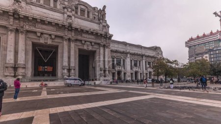 Foto de Panorama que muestra el timelapse de Milano Centrale, la principal estación central de trenes de la ciudad de Milán en Italia. Gente caminando en la plaza. Situado en Piazza Duca d 'Aosta cerca del bulevar Via Vittor Pisani - Imagen libre de derechos