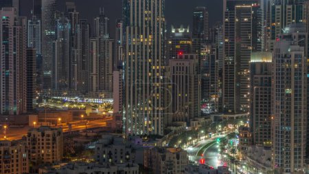 Téléchargez les photos : Paysage urbain aérien futuriste pendant toute la nuit avec une architecture illuminée du centre-ville de Dubaï et de la baie d'affaires. Grands gratte-ciels et tours. Émirats arabes unis. - en image libre de droit