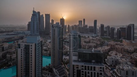 Téléchargez les photos : Vue aérienne panoramique de la ville futuriste nuit à jour transition. Baie d'affaires et quartier du centre-ville avant le lever du soleil avec gratte-ciel et maisons traditionnelles, Dubaï, Émirats arabes unis skyline. - en image libre de droit