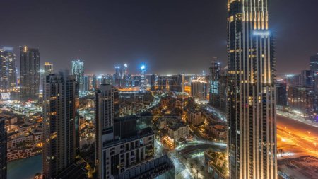 Photo for Aerial panoramic view of city during all night timelapse with lights turning off. Business bay and Downtown district with many skyscrapers and traditional houses, Dubai, United Arab Emirates skyline. - Royalty Free Image