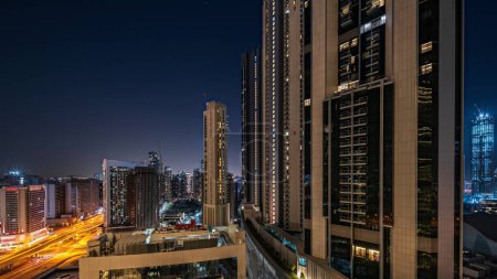 Photo for Panorama showing tallest skyscrapers during Earth hour in downtown Dubai located on boulevard street near shopping mall aerial night timelapse. Lights turning off for one hour - Royalty Free Image