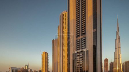 Foto de Los rascacielos más altos del centro de Dubái y la bahía de negocios se encuentran en la calle Boulevard, cerca de la antena del centro comercial durante toda la noche y el amanecer. Iluminación y luces apagadas - Imagen libre de derechos