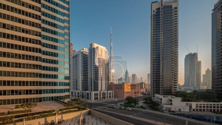 Téléchargez les photos : Vue panoramique aérienne du centre-ville de Dubaï et des gratte-ciels difc avec un trafic achalandé à l'intersection dans le quartier de Business Bay, nuit au jour, période de transition pendant le lever du soleil. - en image libre de droit
