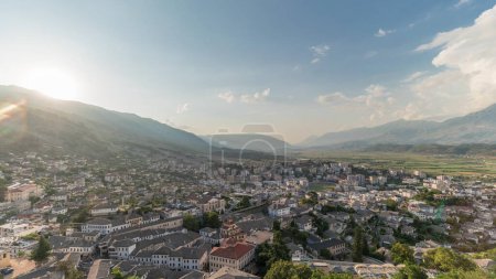 Foto de Panorama que muestra la ciudad de Gjirokastra durante la puesta del sol desde el punto de vista de la fortaleza del castillo otomano de Gjirokaster timelapse. Albania vista aérea con puesta de sol - Imagen libre de derechos