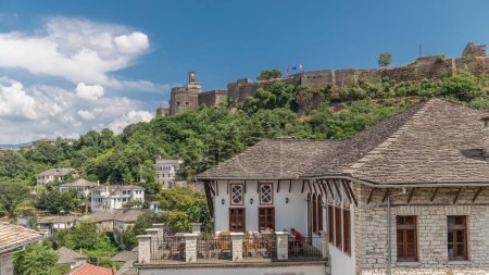 Téléchargez les photos : Panorama montrant la ville de Gjirokastra du point de vue de la forteresse du château ottoman de Gjirokaster timelapse. Albanie vue aérienne vers des maisons historiques typiques avec des toits en pierre - en image libre de droit