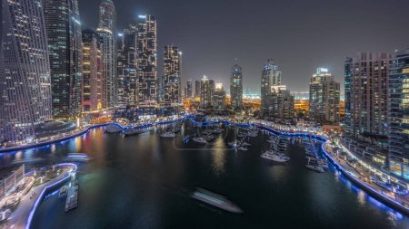 Foto de Dubai marina rascacielos más altos y yates en la antena del puerto día a la transición nocturna después de la puesta del sol. Vista en edificios de apartamentos, hoteles y bloques de oficinas, desarrollo residencial moderno de los EAU - Imagen libre de derechos