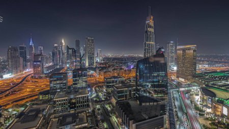 Foto de Panorama que muestra el horizonte futurista del centro de Dubái y del distrito financiero durante la noche aérea. Muchas torres iluminadas y rascacielos con tráfico en las calles - Imagen libre de derechos