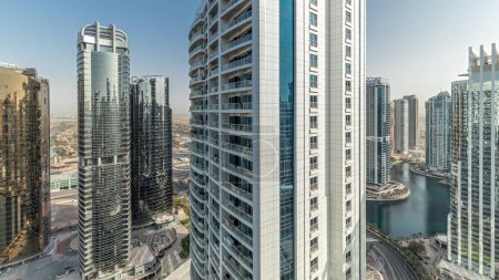 Téléchargez les photos : Panorama montrant de hauts bâtiments résidentiels au JLT district timelapse aérien, qui fait partie du Dubaï multi-commodités centre quartier à usage mixte. Villa maisons sur un fond - en image libre de droit