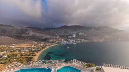 Photo for Panorama showing Amorgos island aerial timelapse from above with clouds before sunset. Traditional Greece - white houses on hills and turquoise sea, Cyclades - Royalty Free Image