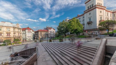 Photo for Panorama showing Sulkowski Castle and fountain on Chrobry Square in Bielsko-Biala timelapse, Poland. Historic buildings around. People walking and sitting in cafe. Clouds on a blue sky - Royalty Free Image