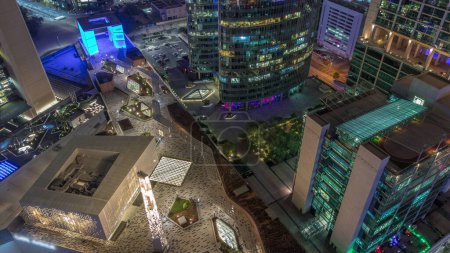 Téléchargez les photos : Dubaï gratte-ciel de centre financier international et promenade sur une avenue porte aérienne de jour à nuit passage timelapse. Les tours éclairées et la mosquée regardent vers le bas vue d'en haut - en image libre de droit