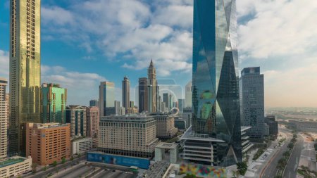 Photo for Sunrise in Dubai International Financial district transition timelapse. Panoramic aerial view of business office towers at morning. Skyscrapers with hotels and shopping malls near downtown - Royalty Free Image