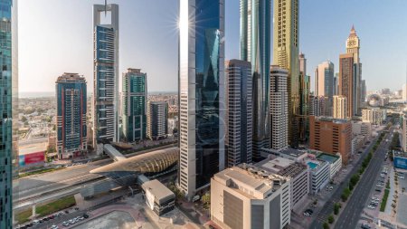 Foto de Vista aérea del Distrito Financiero Internacional de Dubái con muchos rascacielos timelapse durante todo el día con sombras moviéndose rápido y reflejos de vidrio. Tráfico en carreteras cerca de torres de varios pisos. Dubai, Emiratos Árabes Unidos. - Imagen libre de derechos