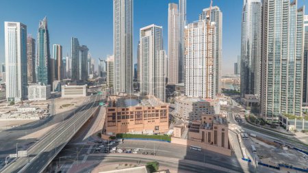 Foto de Vista aérea del horizonte del centro de Dubái con sombras en movimiento desde muchas torres timelapse. Área de negocios en la ciudad urbana inteligente. Rascacielos y edificios de gran altura desde arriba, EAU. Tráfico en la carretera - Imagen libre de derechos