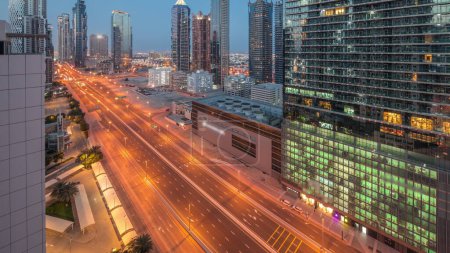 Téléchargez les photos : Business bay district skyline architecture moderne nuit au jour passage timelapse d'en haut. Panorama aérien des gratte-ciel et des tours de Dubaï près de l'autoroute principale avant le lever du soleil. Trafic au carrefour - en image libre de droit