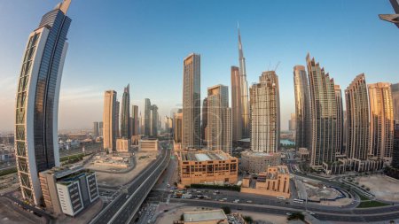 Téléchargez les photos : Vue aérienne du coucher du soleil sur Dubai Downtown skyline avec des tours de jour à nuit transition timelapse panorama. Zone d'affaires dans la ville urbaine. Soleil réfléchi par les gratte-ciel et les immeubles de grande hauteur d'en haut, EAU - en image libre de droit