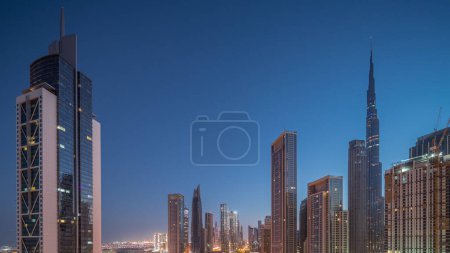 Foto de Vista aérea del amanecer del horizonte del centro de Dubái con muchas torres de noche al día de transición timelapse. Área de negocios en la ciudad urbana inteligente. Rascacielos y edificios de gran altura desde arriba temprano en la mañana, Emiratos Árabes Unidos. - Imagen libre de derechos