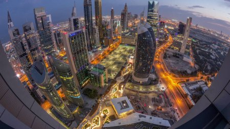 Foto de Skyline panorama de los edificios de gran altura en Sheikh Zayed Road en Dubai noche aérea al día timelapse transición, Emiratos Árabes Unidos. Rascacielos en el Centro Financiero Internacional desde arriba antes del amanecer - Imagen libre de derechos