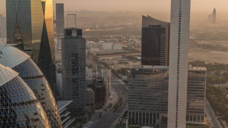Téléchargez les photos : Skyline view of the high-rise buildings around highway road in Dubai aerial timelapse during sunrise, UAE. Les gratte-ciel de la place financière internationale d'en haut tôt le matin - en image libre de droit