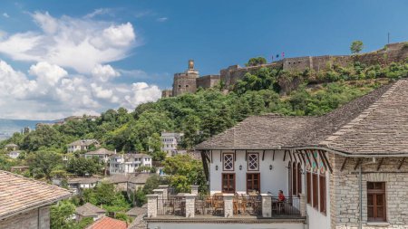 Téléchargez les photos : Panorama montrant la ville de Gjirokastra du point de vue de la forteresse du château ottoman de Gjirokaster timelapse. Albanie vue aérienne vers des maisons historiques typiques avec des toits en pierre - en image libre de droit