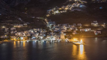 Foto de Amorgos isla aérea día a noche timelapse transición desde arriba después de la puesta del sol. Grecia tradicional - casas blancas iluminadas en colinas y mar turquesa, Cícladas - Imagen libre de derechos