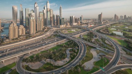 Photo for Panorama of Dubai Marina highway intersection spaghetti junction . Illuminated tallest skyscrapers and golf course on a background. Aerial top view from JLT district before sunrise - Royalty Free Image