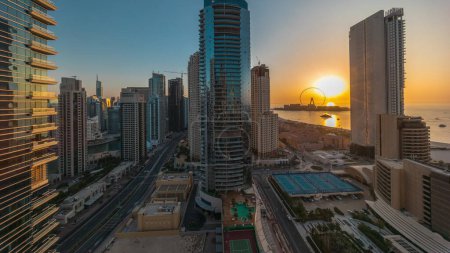 Téléchargez les photos : Vue panoramique sur la Marina de Dubaï et le quartier JBR et sur la célèbre Grande Roue. Timelapse aérien pendant toute la journée jusqu'au coucher du soleil avec des ombres se déplaçant plages de sable rapide et doré dans le golfe Persique - en image libre de droit